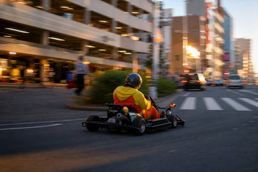 A go-kart turning past an Akihabara arcade