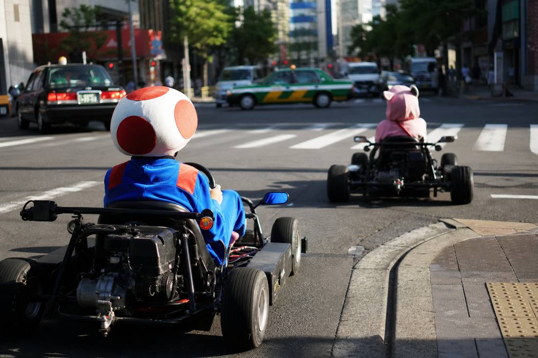 A staff demonstration beside street go-karts in a Tokyo garage
