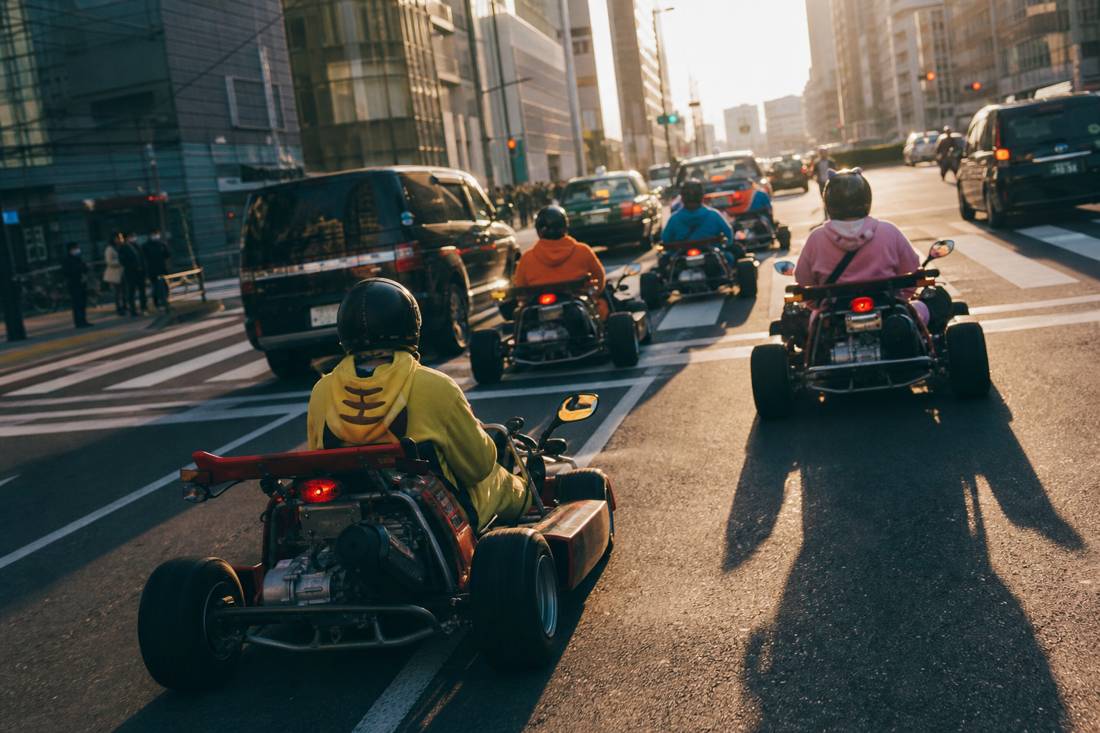 Go-karts in golden-hour light at a Tokyo intersection