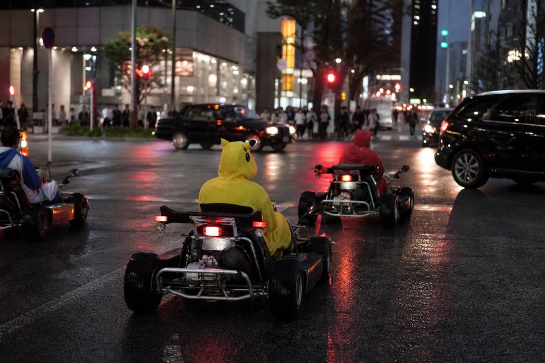 Go-karts on a rainy Tokyo night with neon reflections