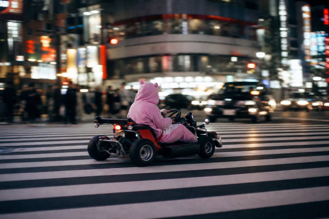 A street go-kart crossing the wide stripes of the Shibuya Scramble