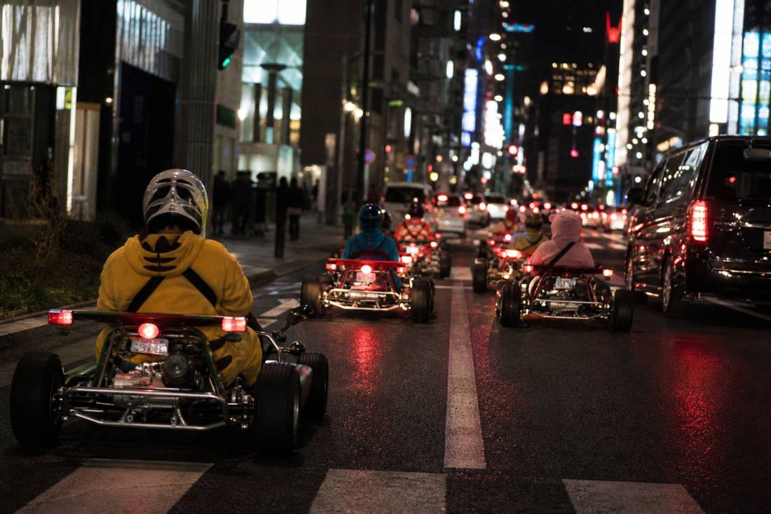 A go-kart convoy pulling out of a Tokyo garage