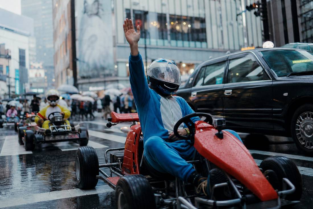A relaxed driver raising a hand at Shibuya Crossing