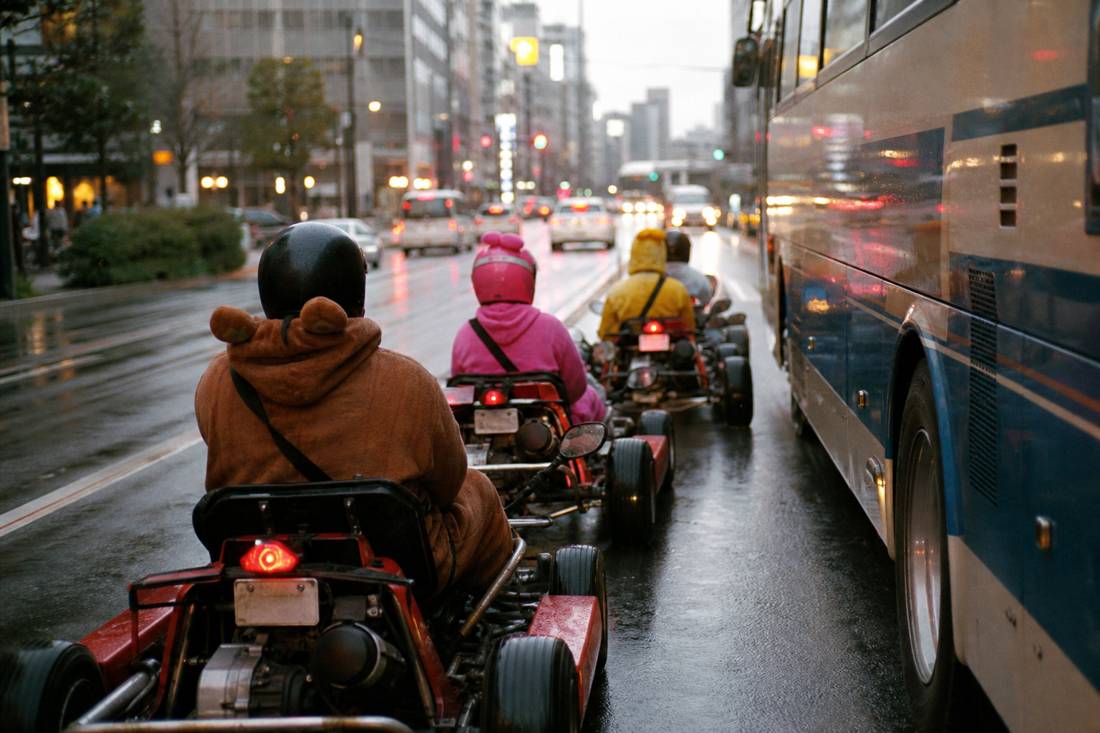 Go-karts keeping lane discipline beside a bus in Tokyo