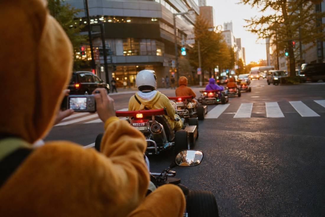 A guide photographing go-kart drivers mid-tour in Tokyo
