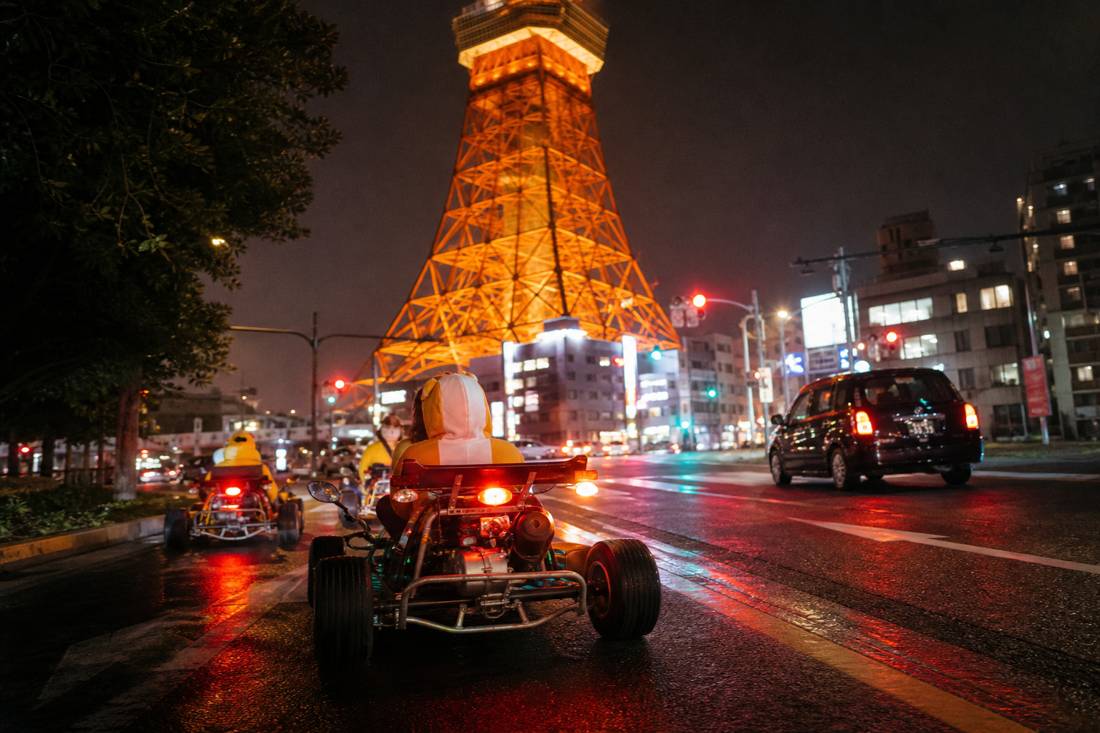 A street go-kart passing beneath Tokyo Tower at night