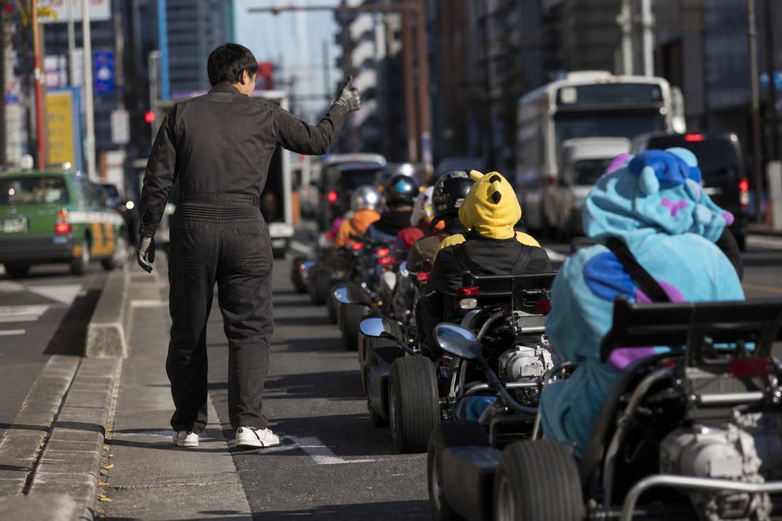 Staff walking seated go-kart drivers through hand signals