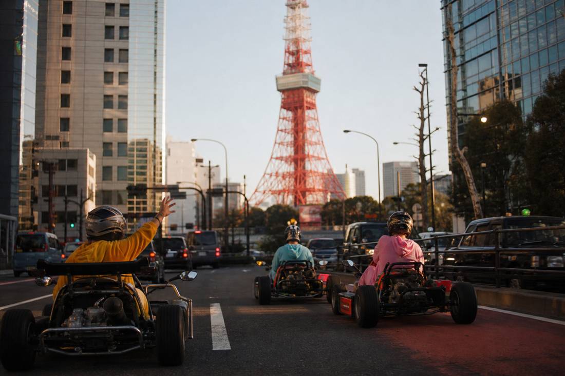 Gentle-paced go-karts passing Tokyo Tower in daylight