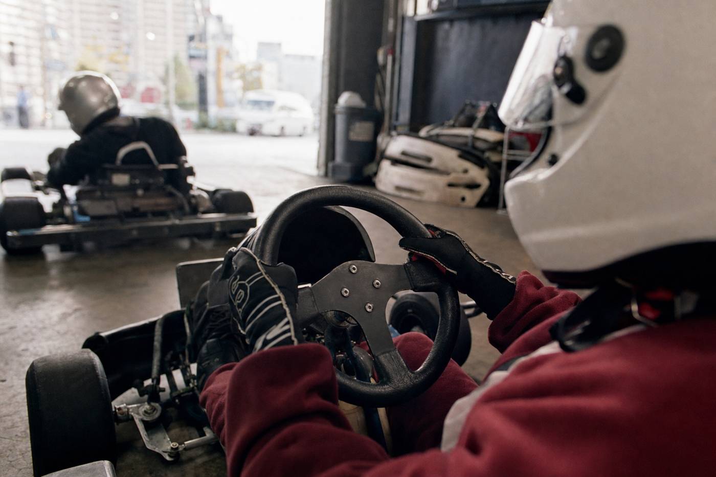 Gloved hands on a street go-kart steering wheel in Tokyo