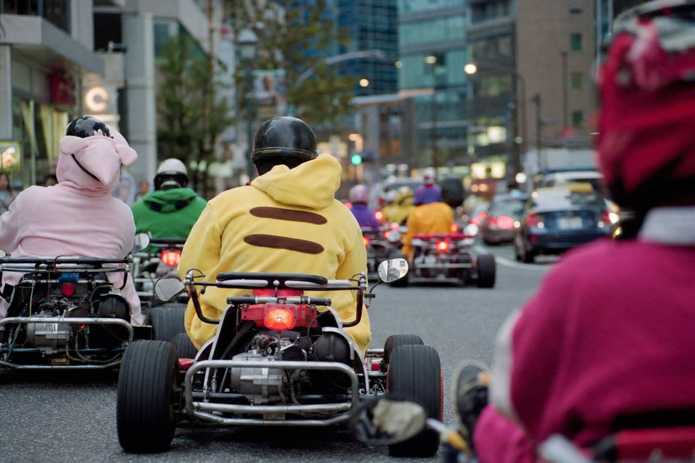A present-day go-kart convoy driving a bright Tokyo street