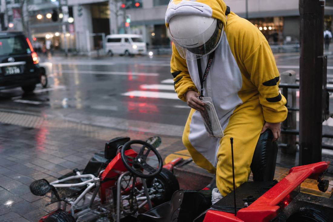 A helmeted driver stepping into a street go-kart