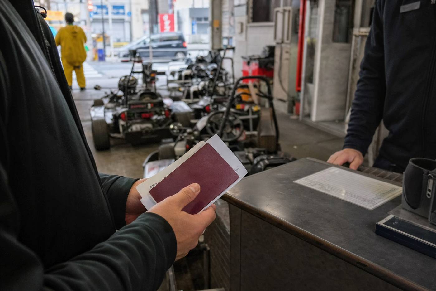 A traveler holding passport and documents at a Tokyo go-kart check-in
