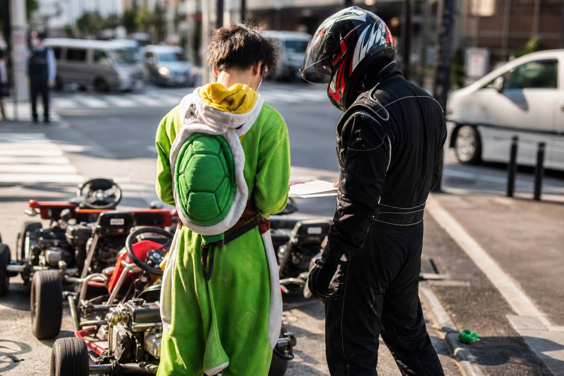 Staff checking paperwork with a go-kart driver in Tokyo