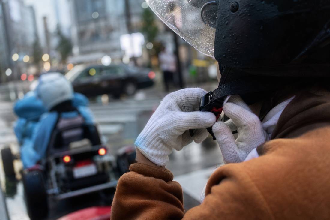 Hands adjusting a go-kart helmet strap